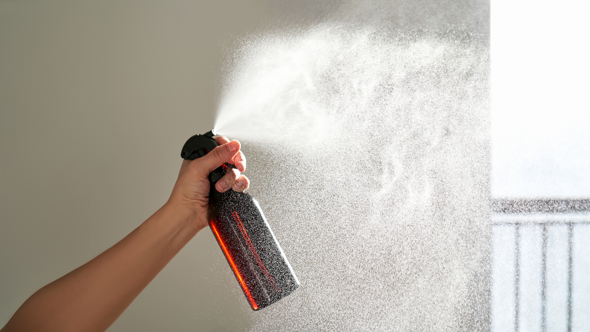 Person spraying room spray bottle