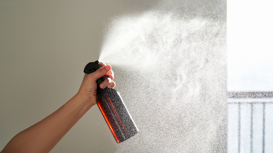 Person spraying room spray bottle