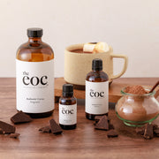 Bottles of 'the eoc' with cocoa products on a wooden surface