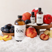 Bottles of 'the eoc' with fruits and snow on a light background