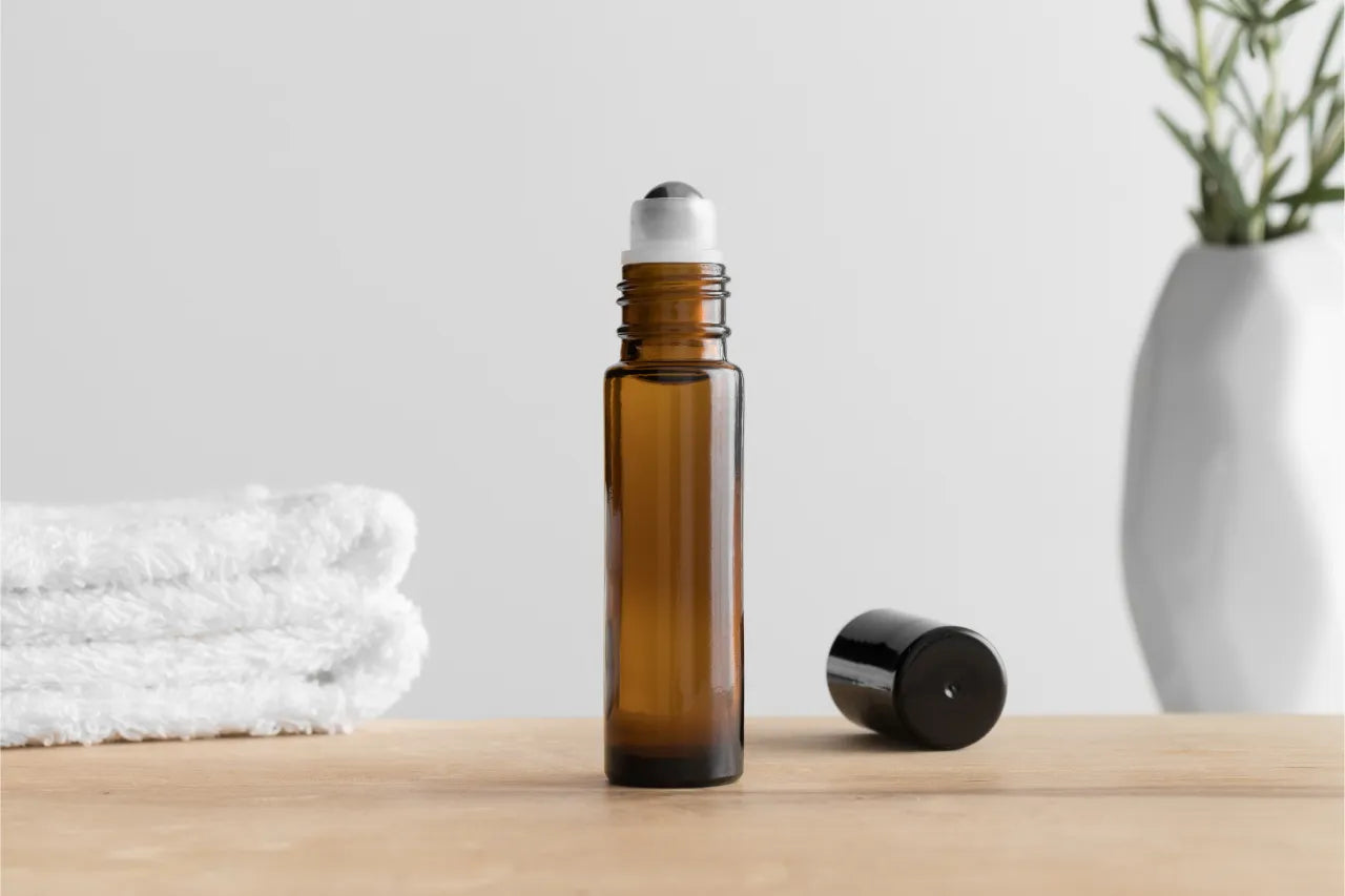 Amber roll-on bottle beside folded towels